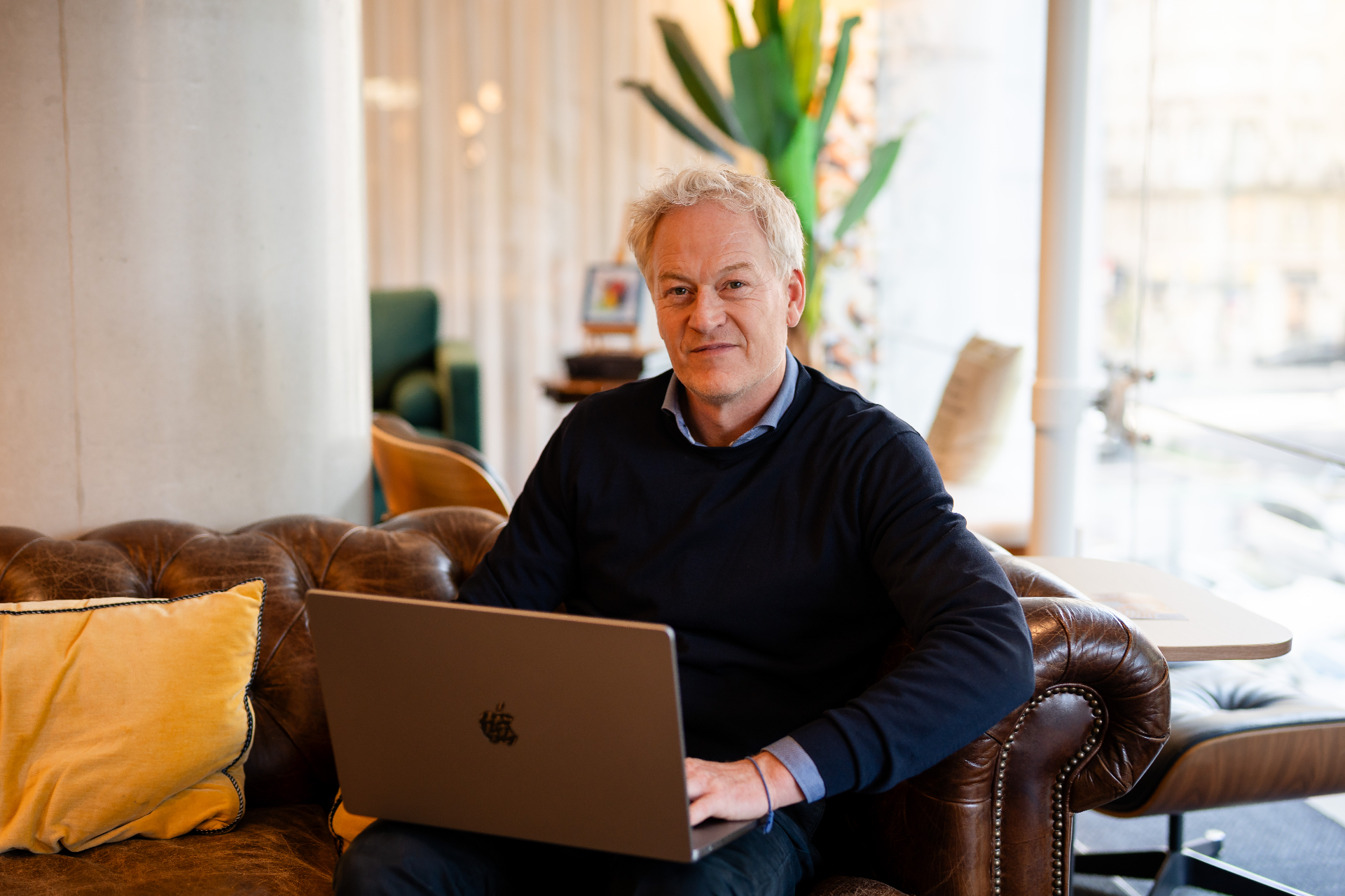 Portret van een Amaii oprichter met laptop in een lichte werkruimte